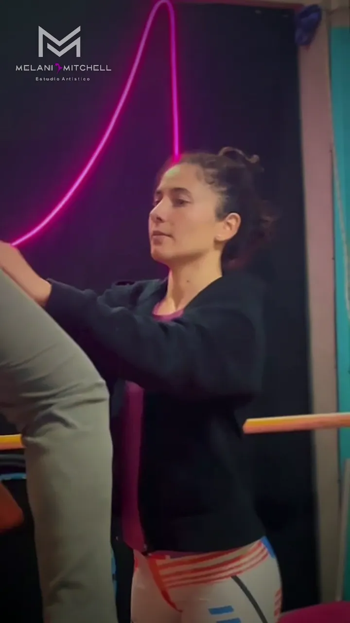 Clase de aro aéreo: una alumna gira sobre el aro mientras la profesora acompaña el movimiento desde el piso